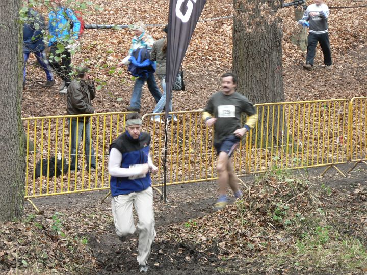 Kunratice06 013.jpg - Nejdřív musel Kroci proběhnout úzkou rozbahněnou uličkou a pak následuje přeskok přes říčku, kde si člověk tradičně nabere vodu do bot. Ani po hodině analyzování způsobu překročení vodního toku, jsme nevymysleli, nic lepšího než potok opravdu proběhnout.